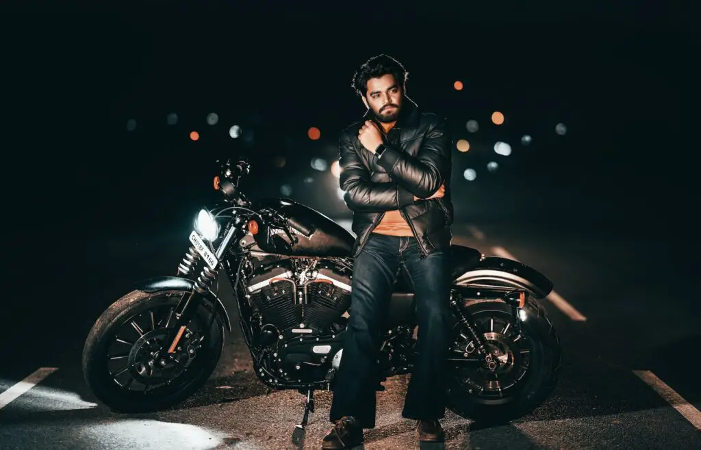 Man in a Black Leather Jacket Posing on His Black Harley Davidson Nightster