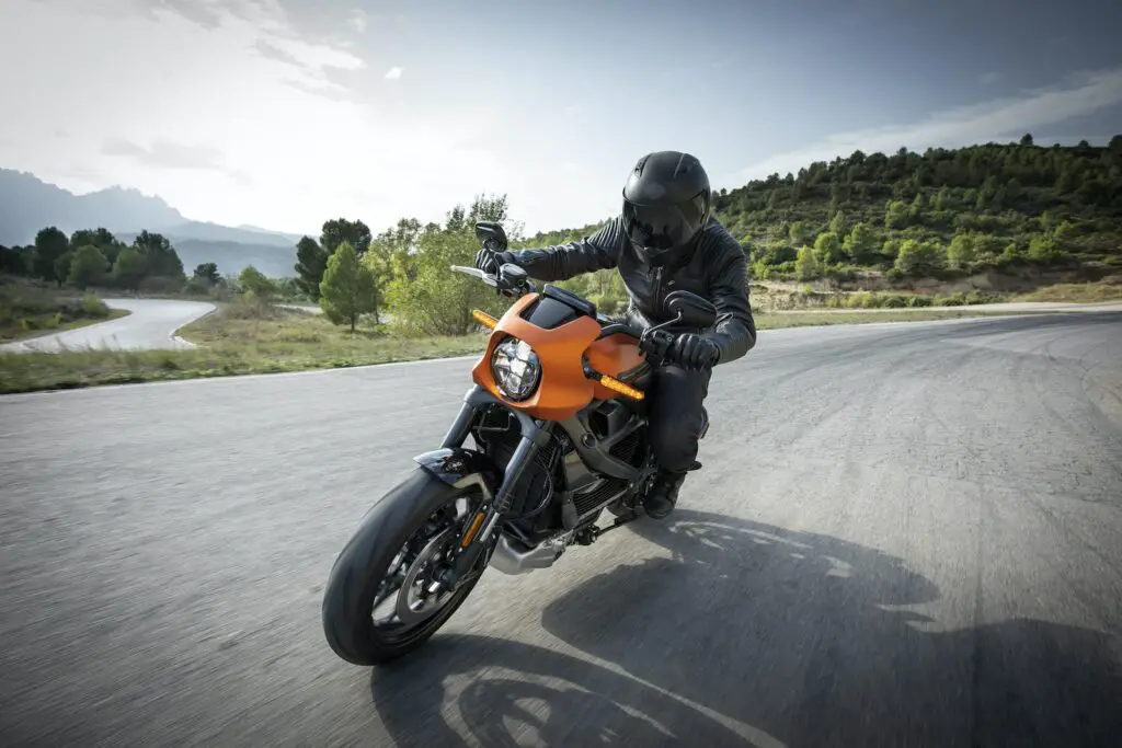 person driving orange motorcycle Harley Davidson Return Policy